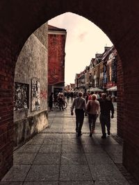 Rear view of people walking on street in city