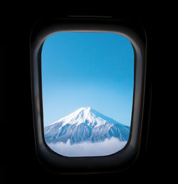 Snowcapped mountain seen through airplane window