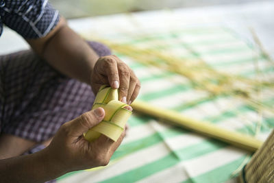 Weaving the coconut leaves making the ketupat, a traditional malay cuisine for the eid celebration.