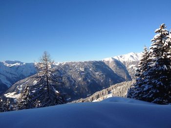 Scenic view of snowcapped mountains against clear blue sky