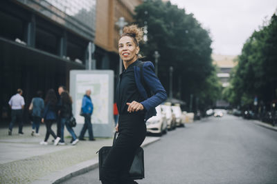 Portrait of smiling young woman in city