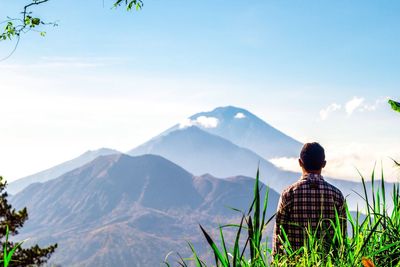 Man standing in front of mountain against sky