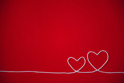 Close-up of heart shape against red background