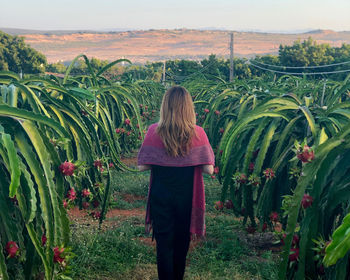 Rear view of woman standing on field