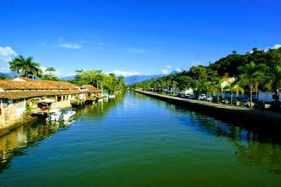 Scenic view of canal against blue sky