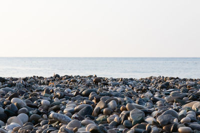 Stones on beach against clear sky