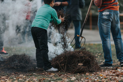 People burning dried twigs on field