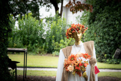 Rear view of woman with pink flower against trees