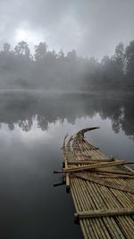 Wooden raft on lake during foggy weather