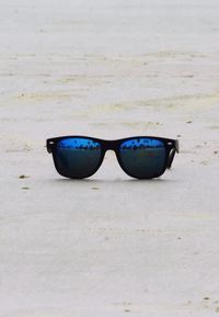 Close-up of sunglasses on sand