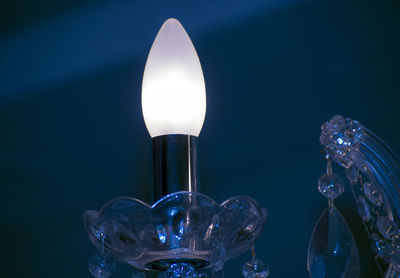 Close-up of illuminated light bulb against black background