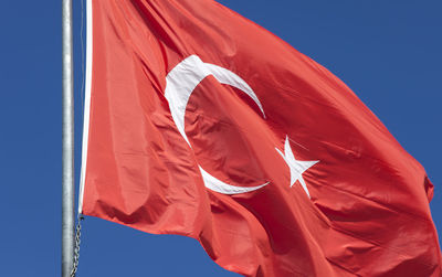 Low angle view of flag against blue sky