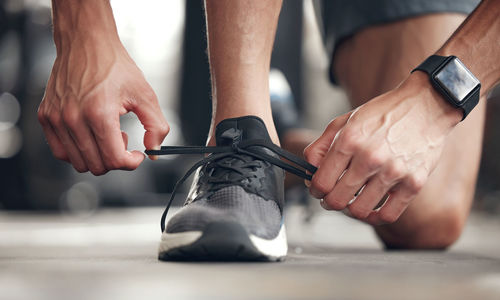 Low section of man tying shoelace