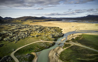 Bridge over calm river in mountainous terrain