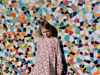 Full length of girl standing against multi colored wall