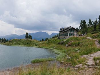 Scenic view of lake by buildings against sky