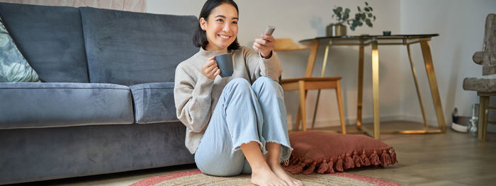 Young woman sitting on sofa at home