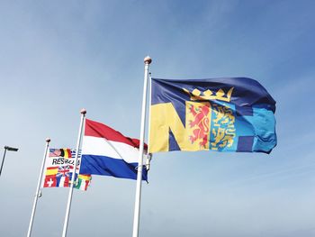 Low angle view of flag flags against blue sky