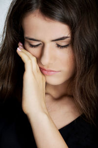 Close-up of young woman wiping tear