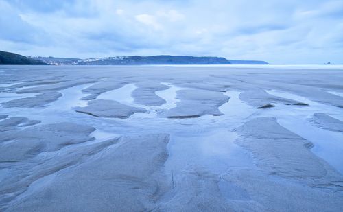 Scenic view of snow covered land against sky