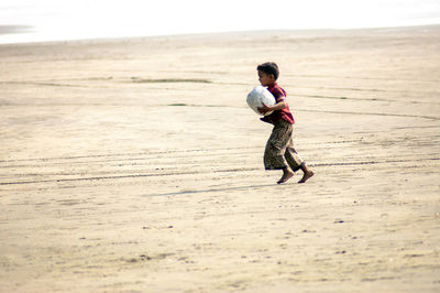 Full length of boy standing on beach