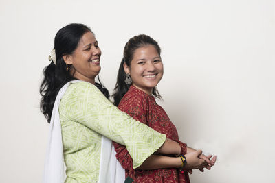 Happy friends standing against white background