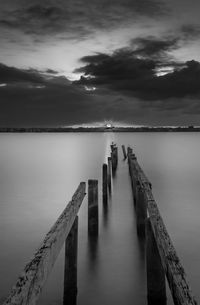 Wooden jetty in sea against sky