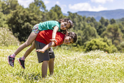 Rear view of two boys on field