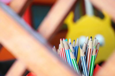 Close-up of colorful pencils seen through wood