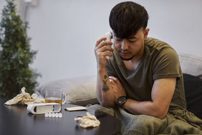 Ill man on sofa using cell phone