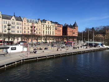 People overlooking river by exterior of building