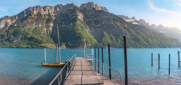 Scenic view of sea by mountains against sky