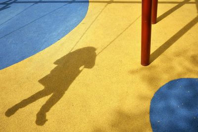 Shadow of person on playground swing