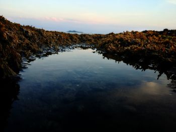 Scenic view of lake against sky during sunset