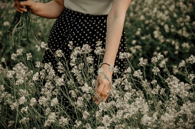 Low section of woman standing on field