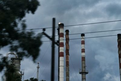 Low angle view of power lines against cloudy sky