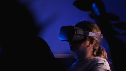 Low angle view of man wearing sunglasses against black background