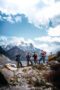 Group of people on rock against sky