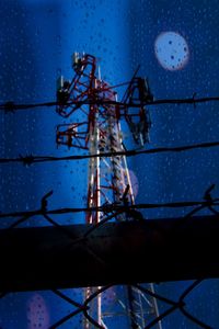 Low angle view of silhouette metallic structure against blue sky