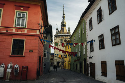 People walking on street amidst buildings in city