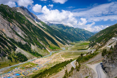 Scenic view of road by mountains against sky