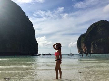 Woman standing in sea against sky