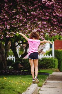 Rear view of woman walking on footpath