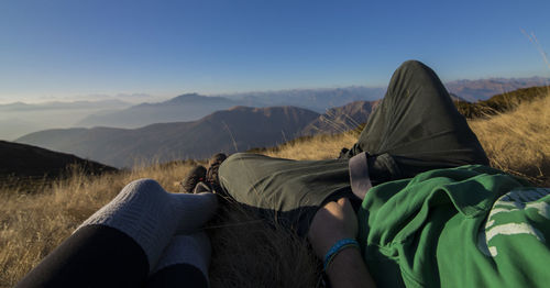 Low section of man relaxing on mountain