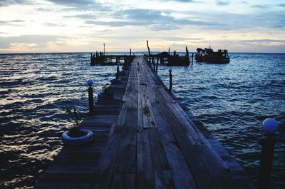 Pier on sea at sunset