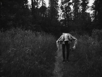 Rear view of man walking in forest