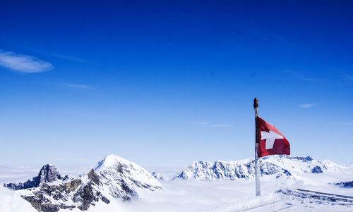 Scenic view of snowcapped mountains against blue sky