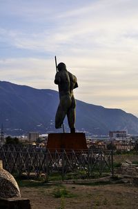 Statue on mountain against sky