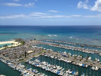 High angle view of city by sea against sky