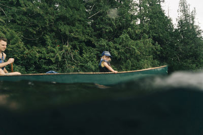 A young girl rides in a canoe with her dad on lost lake in oregon.